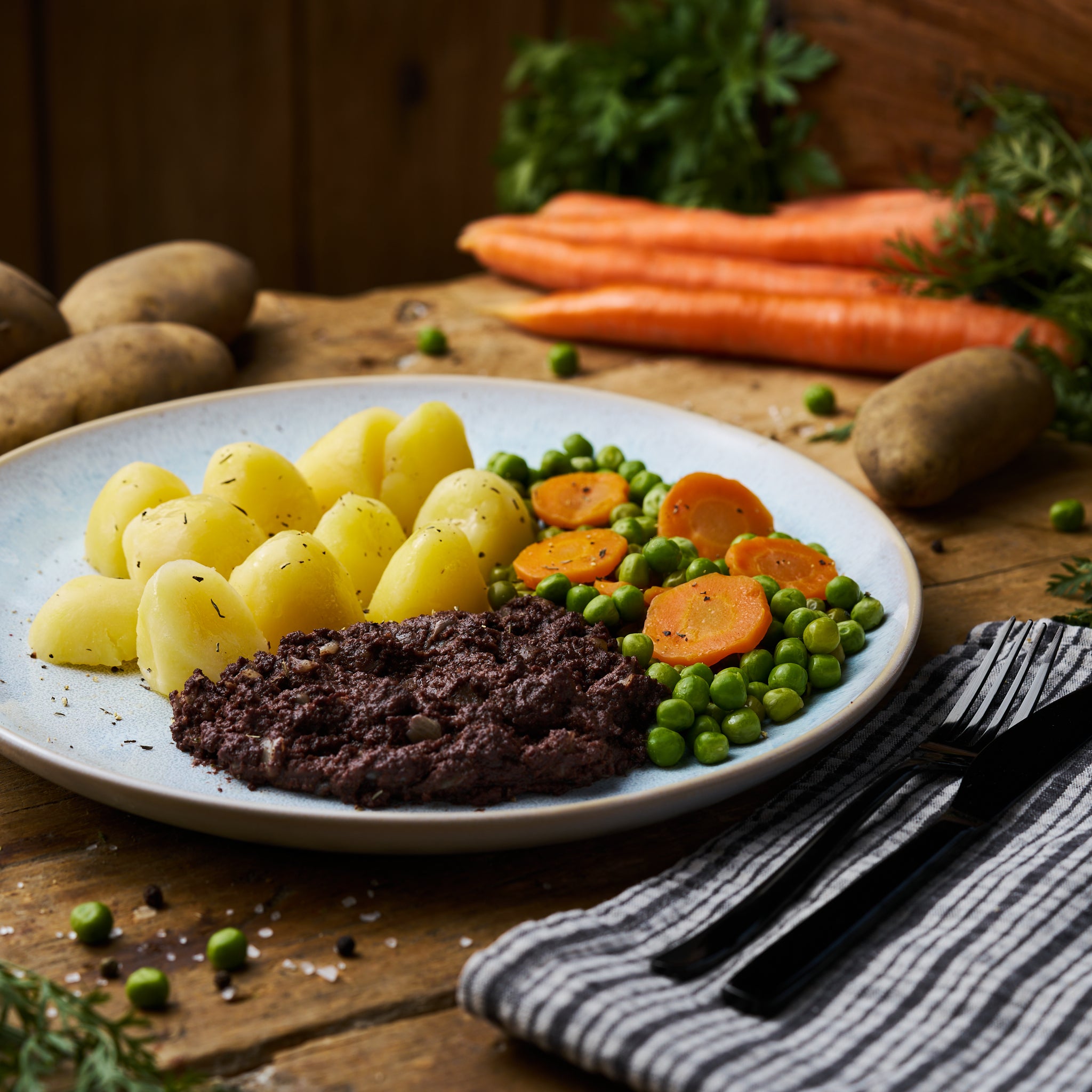 Berliner Blutwurst mit Erbsen-Möhrengemüse und Butterkartoffeln